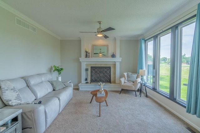 14108 Pine Valley Ct, Basehor, KS 66007 - living room featuring carpet floors, a ceiling fan, baseboards, crown molding, and a fireplace with raised hearth