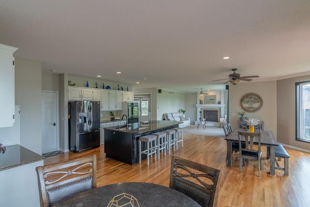 14108 Pine Valley Ct, Basehor, KS 66007 - kitchen with fridge with ice dispenser, a ceiling fan, dark countertops, light wood-style floors, and recessed lighting
