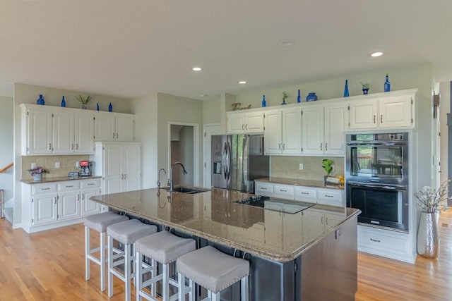 14108 Pine Valley Ct, Basehor, KS 66007 - kitchen with double wall oven, a sink, stainless steel refrigerator with ice dispenser, black electric cooktop, and decorative backsplash