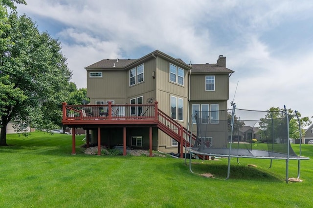 14108 Pine Valley Ct, Basehor, KS 66007 - rear view of property with a trampoline, a deck, a chimney, and a lawn