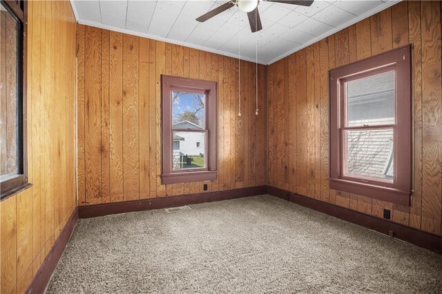 707 E 8th St, Trenton, MO 64683 - carpeted empty room with wooden walls, visible vents, a ceiling fan, and baseboards