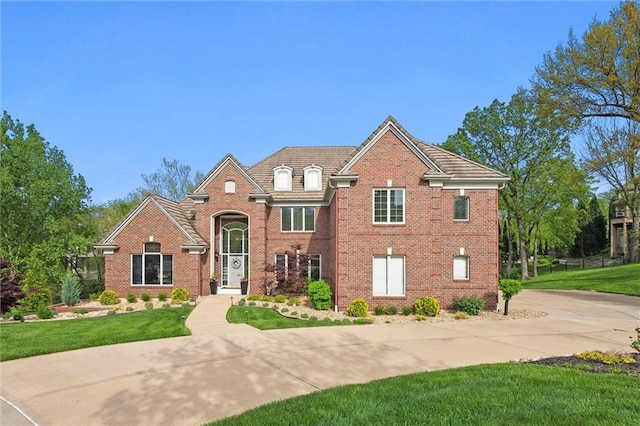 traditional-style house featuring brick siding and a front lawn