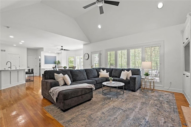 living room with light wood-style floors, high vaulted ceiling, a ceiling fan, and recessed lighting