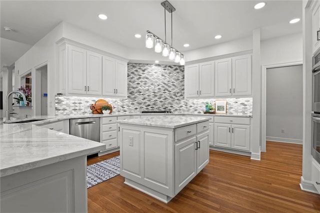 kitchen featuring a sink, white cabinets, and light stone countertops