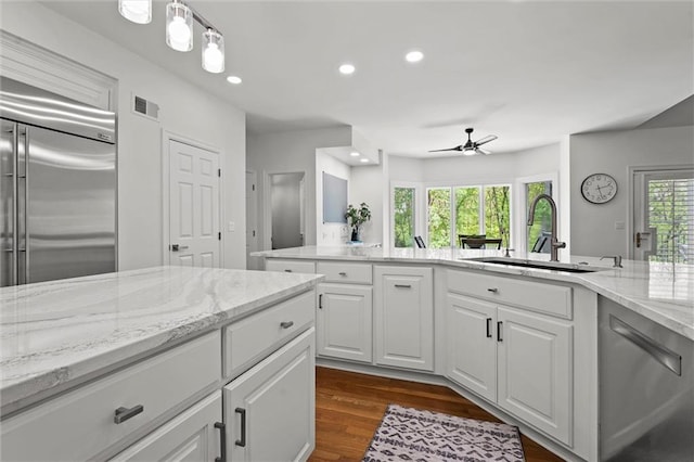 kitchen with appliances with stainless steel finishes, a sink, a ceiling fan, white cabinetry, and recessed lighting