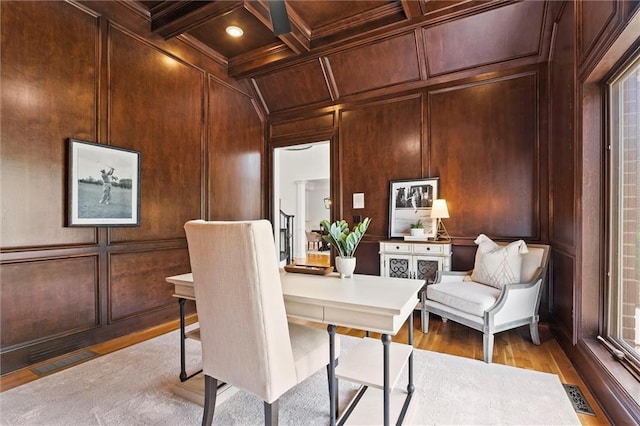 office space with visible vents, light wood-style flooring, and a decorative wall