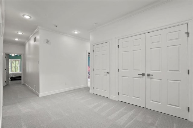 unfurnished bedroom featuring baseboards, light colored carpet, ornamental molding, and visible vents