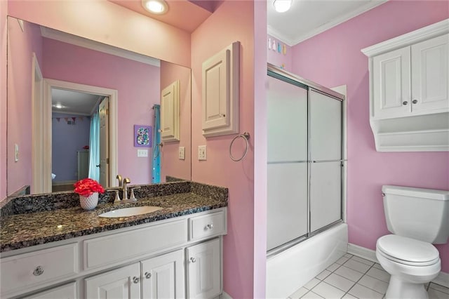 bathroom with vanity, toilet, tile patterned floors, baseboards, and ornamental molding