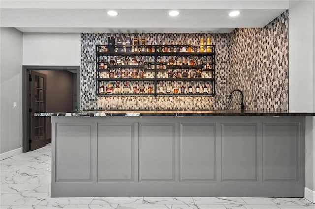 bar with baseboards, recessed lighting, wet bar, and marble finish floor