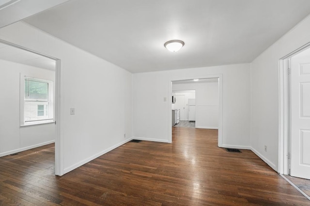 unfurnished room with wood-type flooring and baseboards