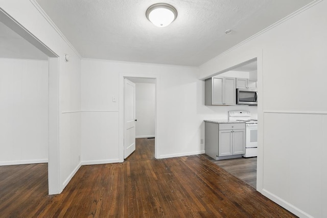 kitchen featuring electric stove, stainless steel microwave, gray cabinetry, dark wood-type flooring, and crown molding