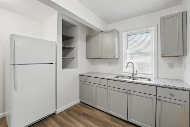 kitchen with freestanding refrigerator, a sink, gray cabinets, and dark wood-style flooring
