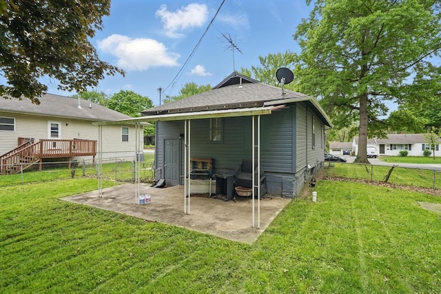 rear view of house featuring a patio area and roof with shingles