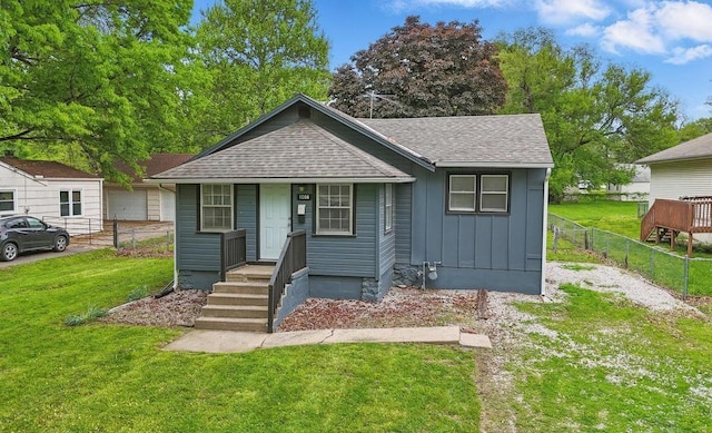 bungalow with board and batten siding, roof with shingles, and covered porch