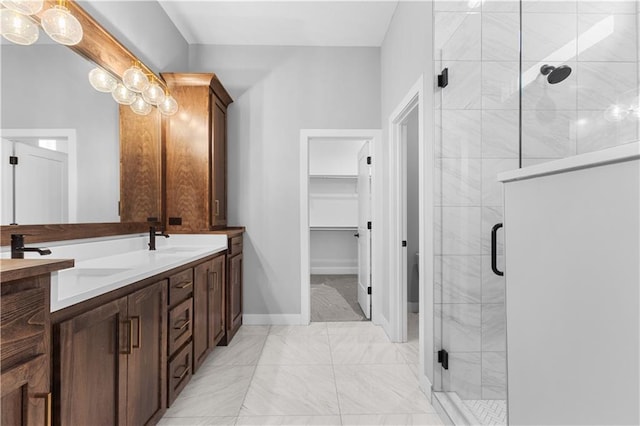 24919 W 145th St, Olathe, KS 66061 - bathroom featuring marble look tiles, double vanity, a shower stall, a walk in closet, and baseboards