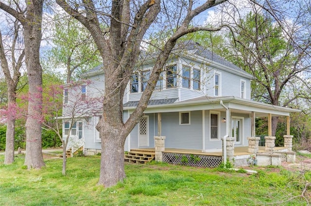 611 E 8th St, Wellsville, KS 66092 - view of front of house featuring a porch, roof with shingles, and a front yard