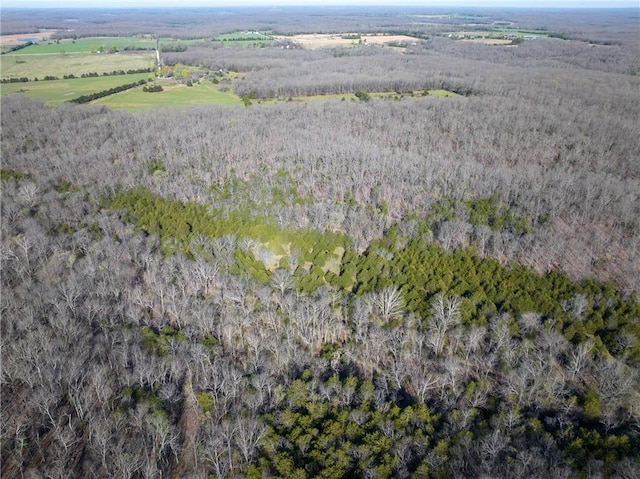 aerial view of property and surrounding area with a heavily wooded area