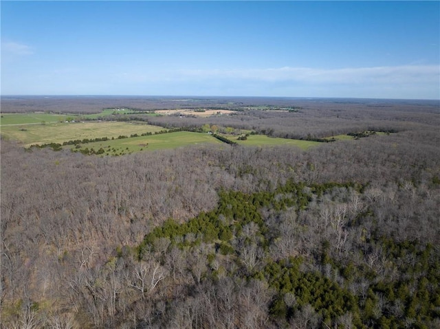 aerial view of property and surrounding area featuring a forest