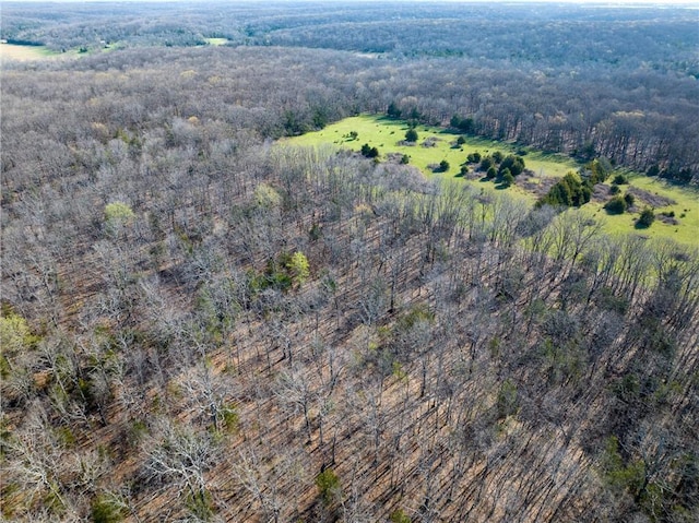 aerial view of property and surrounding area with a heavily wooded area