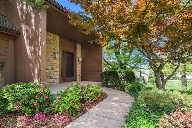 property entrance featuring covered porch and stone siding