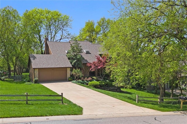 view of front of home with fence, an attached garage, a shingled roof, a front lawn, and concrete driveway