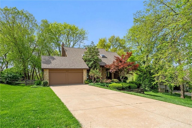 view of front of house with a garage, concrete driveway, roof with shingles, and a front yard