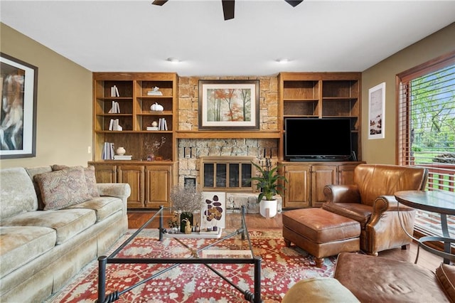 living area featuring ceiling fan, wood finished floors, and built in shelves