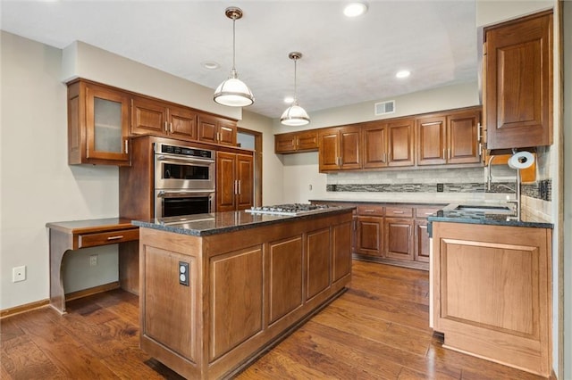 kitchen featuring visible vents, appliances with stainless steel finishes, and brown cabinets