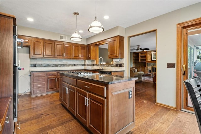 kitchen featuring a ceiling fan, visible vents, tasteful backsplash, stainless steel gas cooktop, and light wood-style floors
