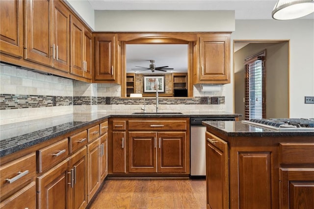 kitchen with brown cabinets, ceiling fan, appliances with stainless steel finishes, and a sink