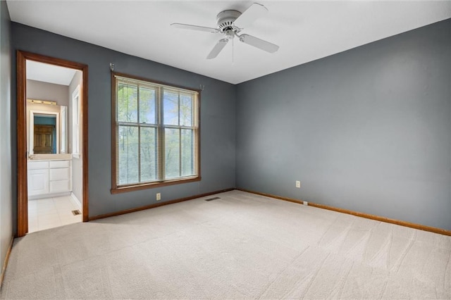 carpeted empty room with a ceiling fan and baseboards