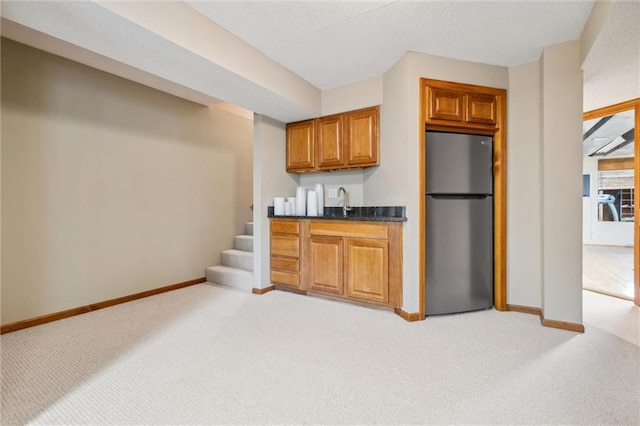 bar with light colored carpet, freestanding refrigerator, baseboards, and wet bar