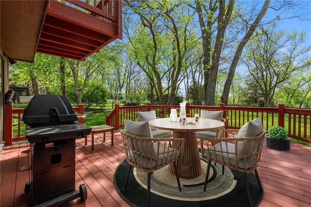 wooden deck with outdoor dining area and area for grilling
