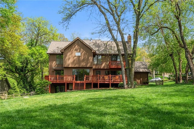rear view of property with a lawn, a shingled roof, a wooden deck, and a chimney