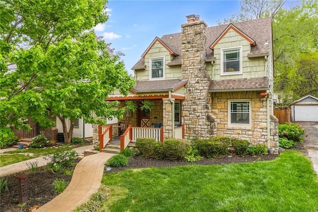 cape cod home with a porch, stone siding, a shingled roof, and a garage