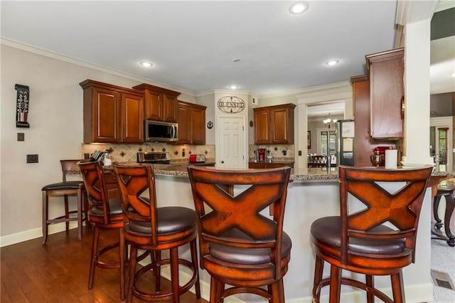 8912 NE 97th St, Kansas City, MO 64157 - kitchen featuring stainless steel microwave, a peninsula, and tasteful backsplash