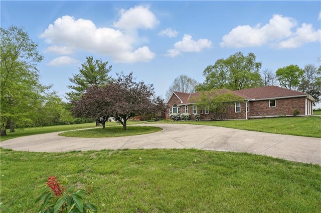 view of front of house featuring curved driveway and a front yard