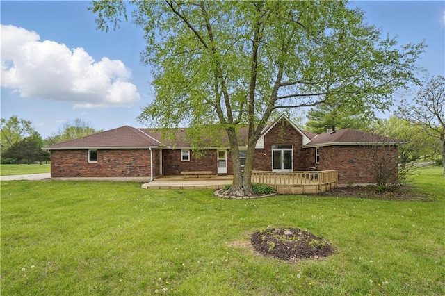 ranch-style home featuring brick siding, a wooden deck, and a front yard