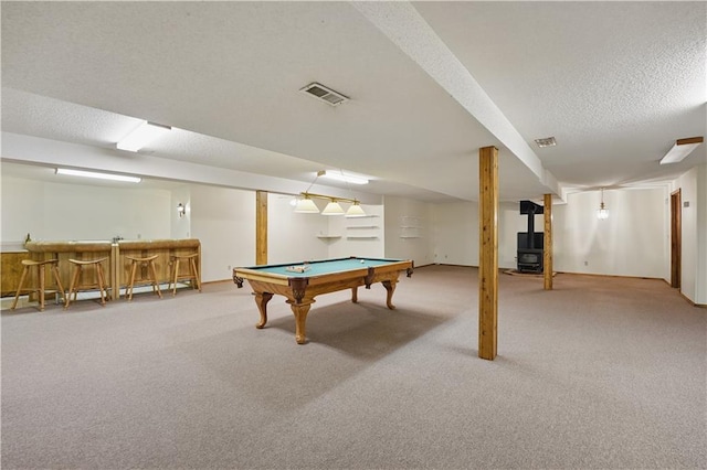 game room with carpet flooring, a wood stove, billiards, indoor bar, and visible vents