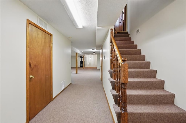 stairway with carpet floors and visible vents