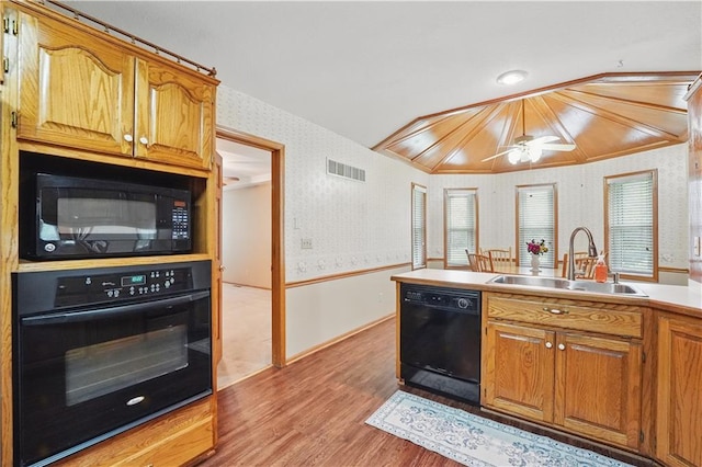kitchen with a sink, black appliances, wallpapered walls, and visible vents