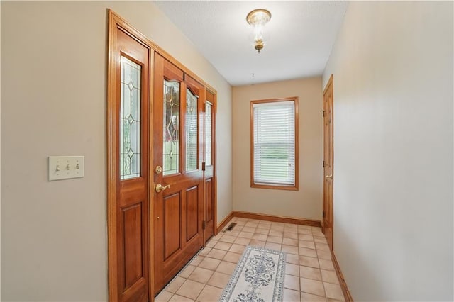 entrance foyer with baseboards, light tile patterned floors, and visible vents