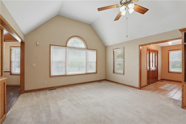 interior space with carpet flooring, visible vents, a ceiling fan, baseboards, and vaulted ceiling