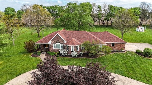 view of front of house featuring a storage unit, a front lawn, and an outbuilding