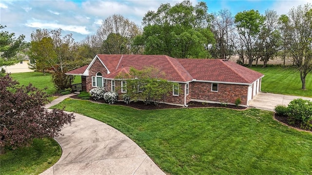 view of property exterior with brick siding, a yard, and driveway