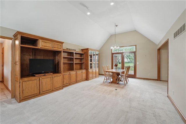 dining room featuring light colored carpet, a chandelier, baseboards, lofted ceiling, and visible vents