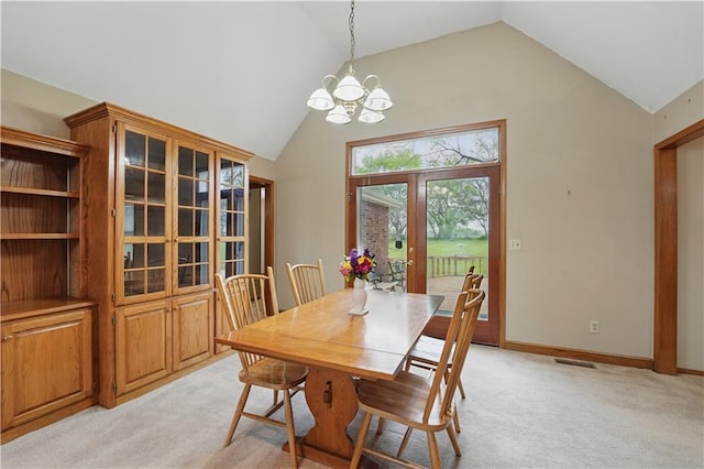 dining space featuring an inviting chandelier, light carpet, and vaulted ceiling