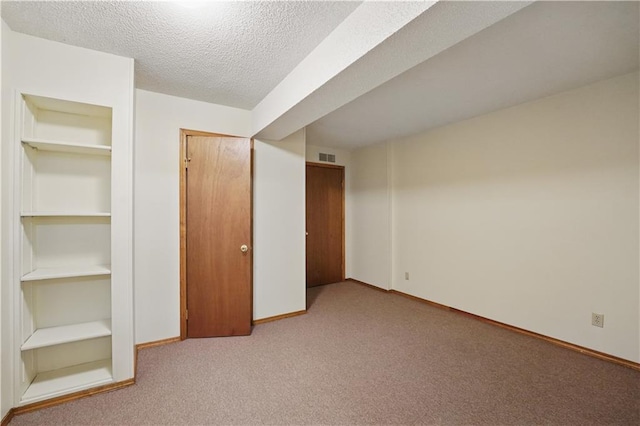 unfurnished bedroom with carpet floors, a textured ceiling, baseboards, visible vents, and a closet