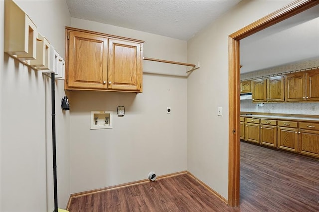 laundry room featuring electric dryer hookup, dark wood finished floors, cabinet space, baseboards, and hookup for a washing machine