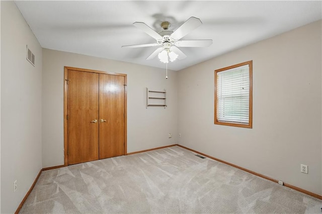unfurnished bedroom with visible vents, baseboards, light carpet, and a closet